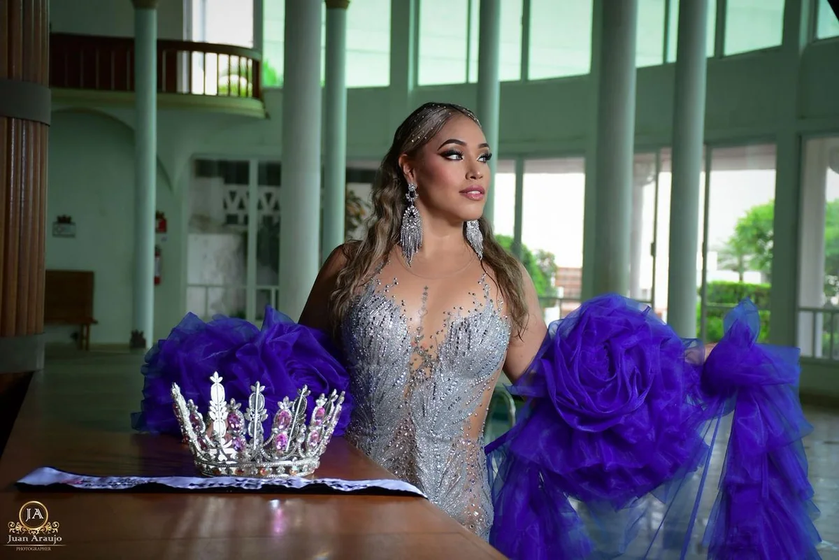 Gabriela Salazar con vestido de gala junto a una corona y detalles violetas